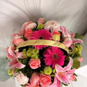 Canasta floral con rosas gerberas lirios y flores mixtas en tonos rosa