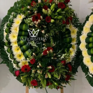 Corona fúnebre roja y blanca de condolencias con rosas rojas, flores blancas y follaje verde en base circular