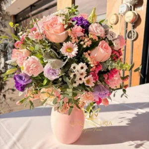 Jarrón floral con rosas margaritas y flores mixtas en tonos rosa lila y blanco