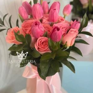 Jarrón floral con tulipanes y rosas en tonos rosa y follaje verde