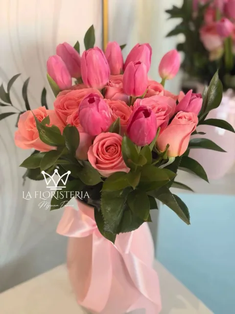 Jarrón floral con tulipanes y rosas en tonos rosa y follaje verde