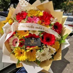 Ramo de gerberas rojas amarillas y blancas con cinta de graduación